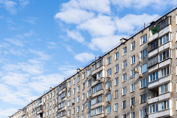 municipal apartment house under blue sky with many light white clouds in Moscow city on cold sunny autumn day