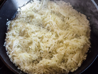 top view of finely chopped onions frying in deep frying pan at home kitchen