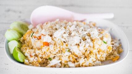 Thai food called Khao pad poo. Delicious Fried rice with crab condensed eggs on a wooden table.