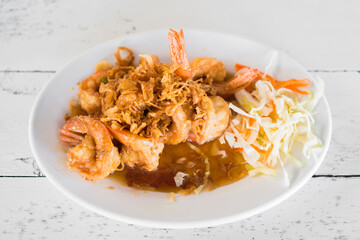 Fried shrimp with tamarind sauce on wooden table.