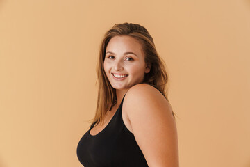 Obraz premium Young woman wearing swimsuit smiling and looking at camera