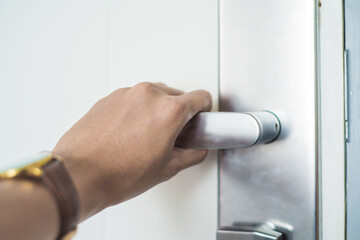 A burglar tries to break in a house, Hand hold handle of metal doorknob lock and unlock doors.