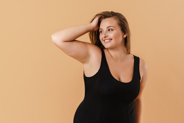 Young woman wearing swimsuit smiling and looking aside