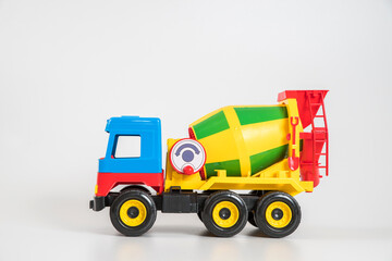 Multi-colored plastic children's toy cars on a white background. Concrete truck.