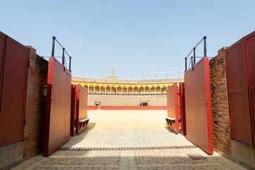 Selbstklebende Fototapeten The entrance gate of the spanish arena named "Plaza de toros" (meaning: bull's arena) where the traditional corrida take place. Blue sky on the background. © Travelling Jack