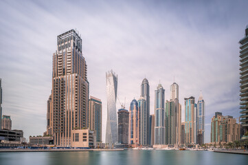 Day view of Dubai Marina bay with cloudy sky, UAE