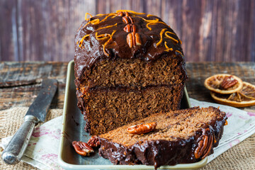 Homemade ginger loaf cake with plum marmalade, pecan nuts and chocolate ganache