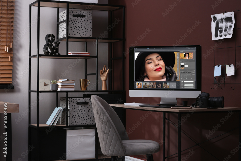 Poster retoucher's workplace. computer with photo editor application, camera and graphic tablet on table in