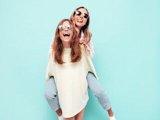 Two young beautiful smiling brunette hipster female in trendy summer clothes. Sexy carefree women...