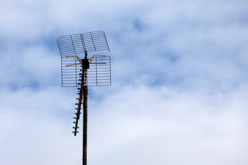 TV antenna on a pole against cloudy sky