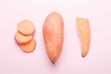 Sweet potato vegetable on a pink background. Sliced ​​sweet potato. In the context.