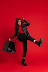 White woman laughing while posing with shopping bags