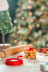 Christmas cookies with red ribbon cooking on the background of the christmas tree