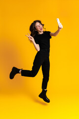 White excited woman gesturing while taking selfie on cellphone