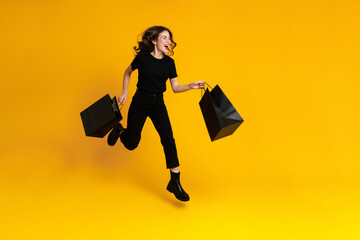 White excited woman laughing while running with shopping bags