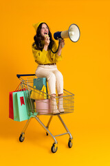 White woman screaming to megaphone while sitting in shopping cart