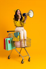 White woman screaming to megaphone while sitting in shopping cart © Drobot Dean