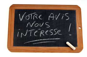 Fototapeta premium Votre avis nous intéresse écrit sur une ardoise d'école à la craie