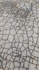 Old asphalt road in wet cracks like mosaic