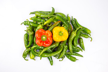 green hot peppers and red and yellow bell peppers on a white background. vitamin vegetables for health