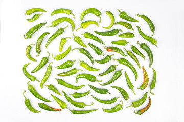 green hot peppers evenly spread on a white background. vitamin vegetables for health