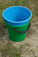 two plastic buckets are on the ground