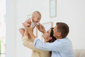 Portrait of happy family with their cute baby at home
