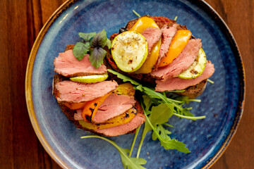 French bruschetta with cream cheese and thin sliced meat and baked vegetables.Concept menu of summer cafe