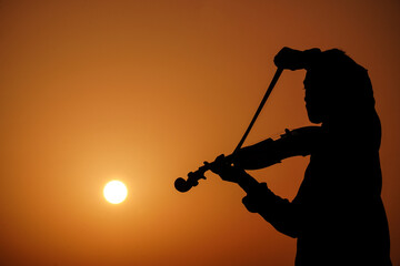 musician playing violin. Music and musical tone concept. silhouette images of man musician