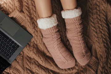Woman on bed with socks and using a laptop