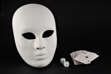 White theatrical mask, playing dice and playing cards