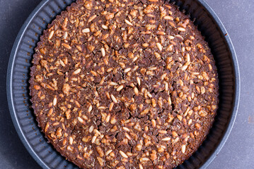 close up of traditional castagnaccio cake, a classic italian gluten free autumn cake on wooden table made with chestnuts flour, pine nuts, rosemary and olive oil. italian bakery and healthy food.