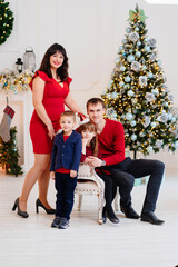 beautiful and happy family at the Christmas tree. 