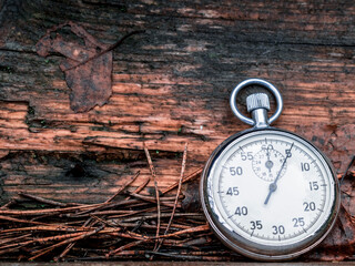 Pocket timer on old grunge wood background in nature.