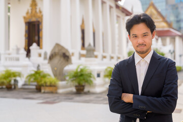 Asian businessman relaxing outdoors in the city at Buddhist temple