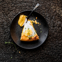Traditional American pumpkin pie with whipped cream and cinnamon on dark table. top view