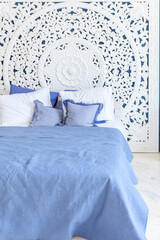 Fototapeta na wymiar Beautiful luxury classic clean interior bedroom in white and deep blue color with king-size bed and chic carved furniture. Bright modern stylish interior bedroom and living room in minimalist style.