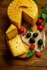 composition of different types of sliced cheese: hard, mature, cheese with mold. Cheese slicing with fruit - grapes and figs. concept is cheese handicraft production, restaurant.