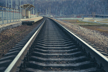 Fototapeta premium Rails stretching into the distance and the railway station. Railway transport, travel, communications.