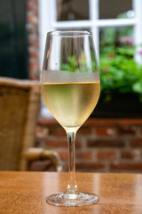 Glass of cold white wine served on outdoor terrace in old French cafe