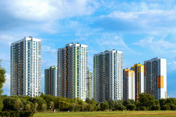 Fototapeta premium A slender series of new multi-storey residential buildings of an ecologically clean area in a big city. Park. Bank