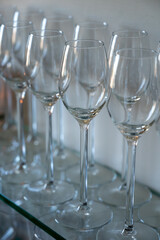 Many empty clean wine glasses on shelf in restaurant