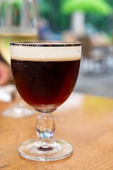 Glass of dark tasty Belgian dubbel brown beer from abbey brewery