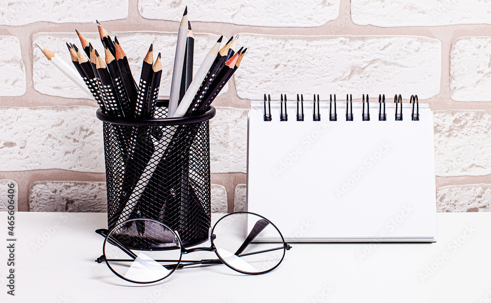 Poster workplace in the house with glasses, pencils in a stand and a blank notebook with a place to insert 