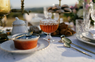 Honey in a glass plate on a beautiful table with food. Honey and red caviar on the table.