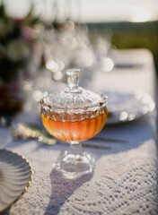 Honey in a glass plate on a beautiful table with food. Honey antique dishes.