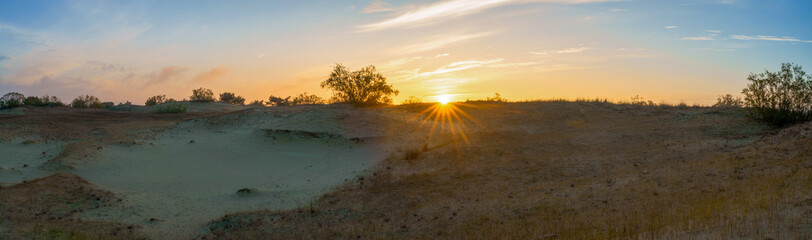 Dawn in the field, the sun rises over the hills