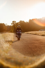 Fototapeta premium Biker in a protective suit with a helmet. Motorcyclist in a helmet and leather jacket rushes along the road on a sports motorcycle