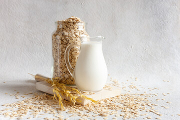 Oat flakes, out milk on a table. Plant-based healthy and vegetarian eating and drink. Selective...