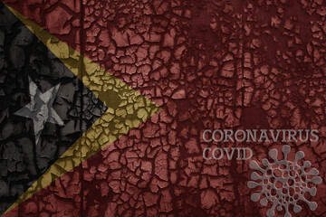 flag of east timor on a old metal rusty cracked wall with text coronavirus, covid, and virus picture.